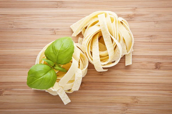 Nido de fettuccine de pasta italiana en tabla de cortar — Foto de Stock