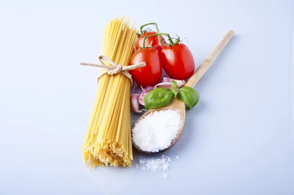 Spaghetti and tomatoes with herbs on an old and vintage wooden t — Stock Photo, Image