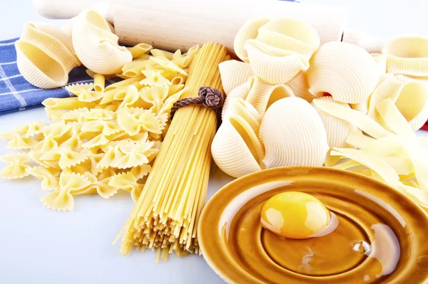 Italian pasta, eggs and rolling pin on a white background — Stock Photo, Image