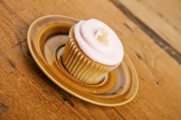 Cupcake on plate over wood background — Stock Photo, Image