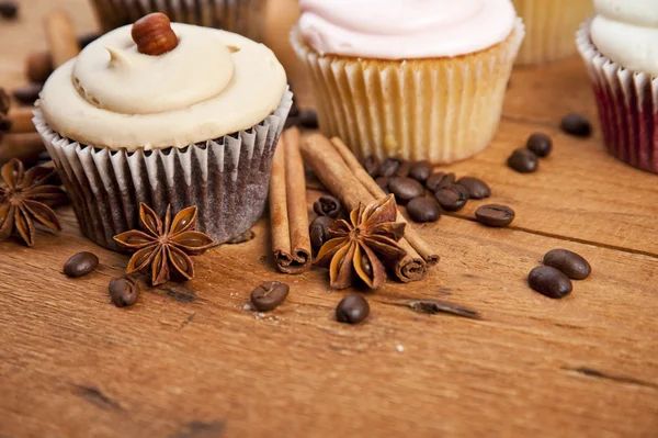 Chocolate cupcake, coffee beans, cinnamon, star anise on sacking — Stock Photo, Image