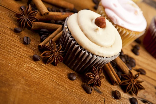 Chocolate cupcake, coffee beans, cinnamon, star anise on sacking — Stock Photo, Image