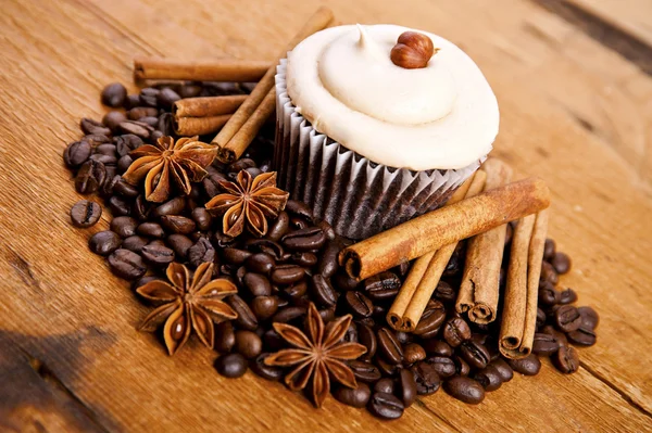 Chocolate cupcake, coffee beans, cinnamon, star anise on sacking — Stock Photo, Image