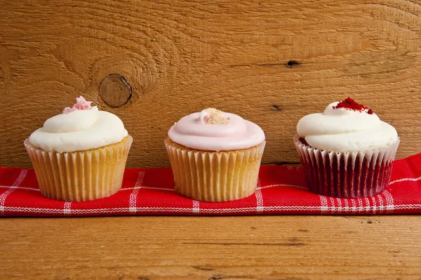 Photo of 3 cupcakes on wooden background — Stock Photo, Image