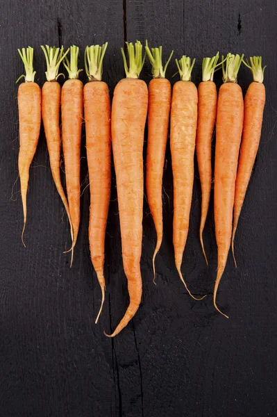 Rå friske gulerødder med haler, top view - Stock-foto