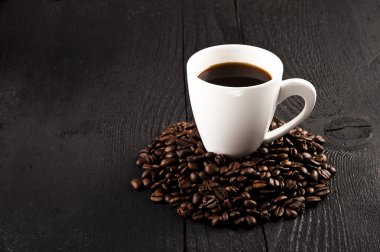 fincan kahve ve koyu arka plan üzerine kahve çekirdekleri