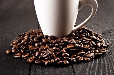 Eski ahşap arka planda kahve fincanı ve kahve çekirdeği.