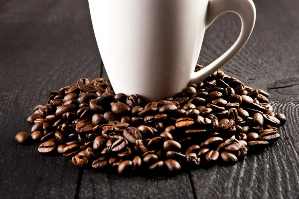 Tasse de café et grains de café sur un vieux fond en bois — Photo