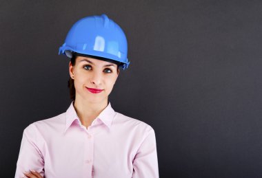 kadın mimar, müteahhit koyu arka plan üzerinde mavi kask içinde