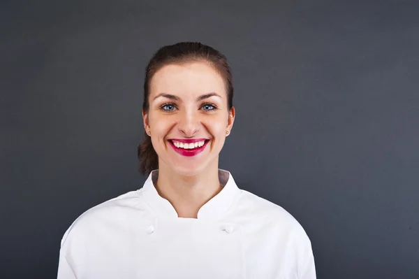 Close-up woman cook look round or hear something, over gray wall — Stock Photo, Image