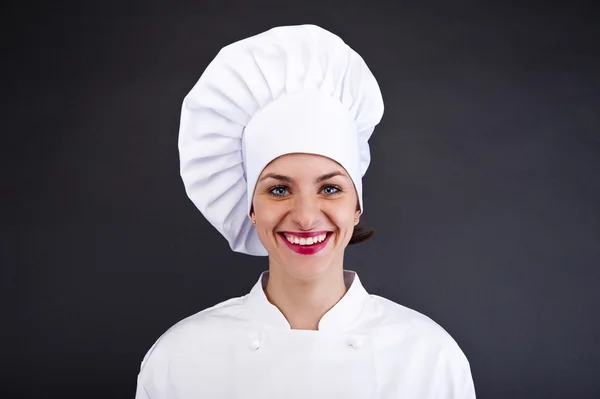 Mulher cozinheira atraente um fundo mais escuro — Fotografia de Stock