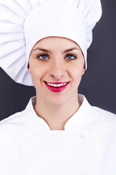 Close-up woman cook look round or hear something, over dark wall — Stock Photo, Image