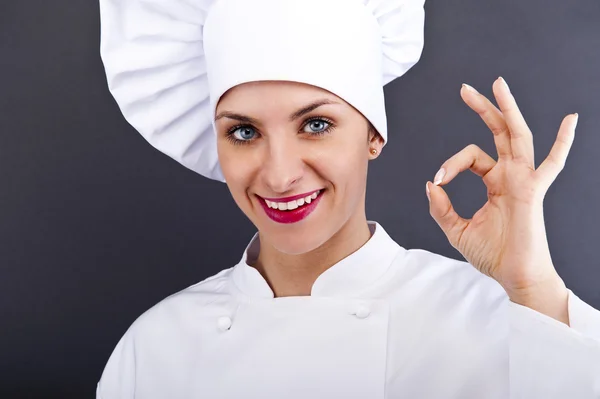 Aantrekkelijke cook vrouw tonen ok over donkere achtergrond — Stockfoto