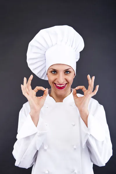 Atractiva cocinera mostrando ok sobre fondo oscuro — Foto de Stock