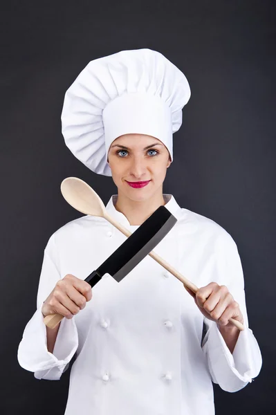 Chef de uniforme sosteniendo un cuchillo de cocina. Aislado sobre fondo oscuro — Foto de Stock