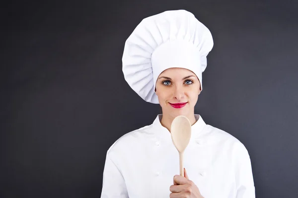 Chef de uniforme segurando uma faca de cozinha. Isolado no escuro backgr — Fotografia de Stock