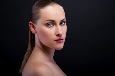 sarışın bir kadın gülümseyerek koyu arka plan üzerinde