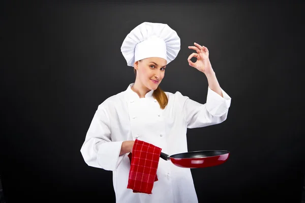 Cheff mujer sobre oscuro fondo sonriendo y ckoking — Foto de Stock