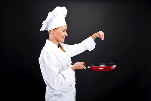 Giovane donna chef con diversi strumenti su sfondo scuro — Foto Stock