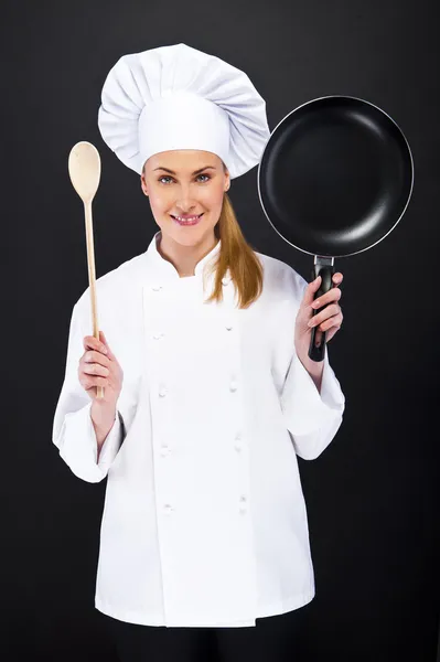 Mulher loira bonita chef segurando pan no fundo escuro branco — Fotografia de Stock