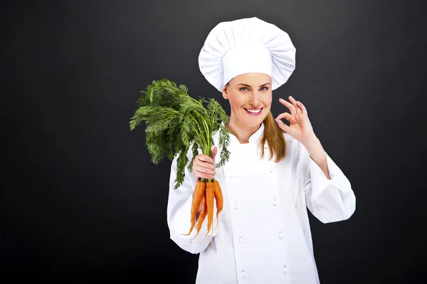 Cocinera en uniforme blanco con racimo de zanahorias — Foto de Stock