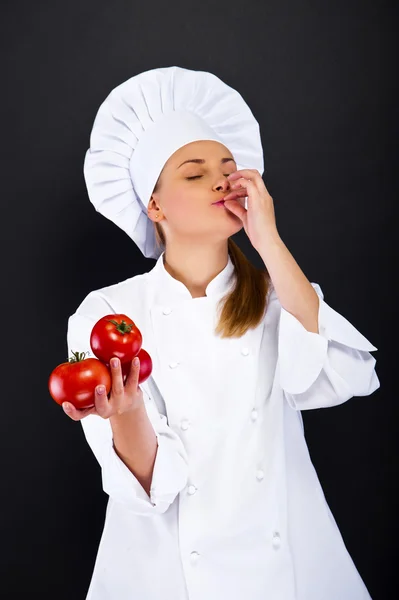 Portret van een jonge vrouw chef-kok met tomaten — Stockfoto