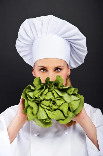 Mujer chef con ensalada befor ella sobre fondo oscuro —  Fotos de Stock