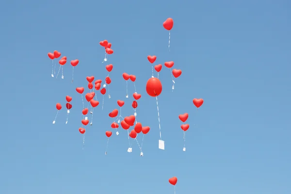 Ballons rouges avec les messages dans le ciel bleu — Photo