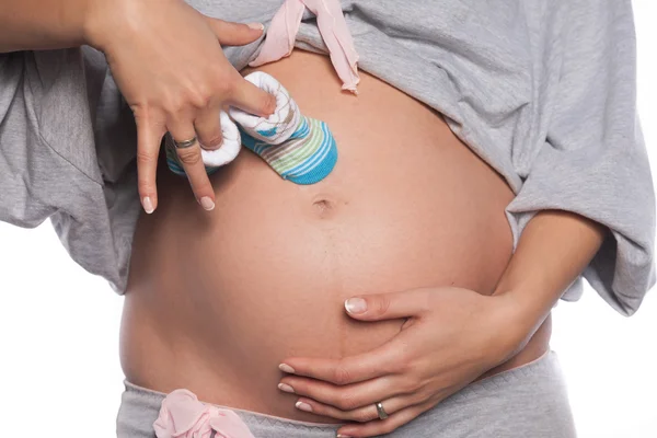 Woman holding baby shoes — Stock Photo, Image