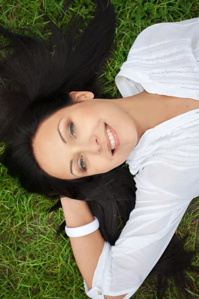 Sorrindo mulher deitado na grama — Fotografia de Stock