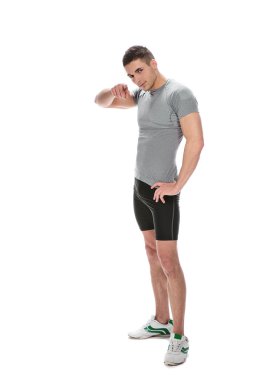 Muscle young guy smiling and pointing at you against white backg