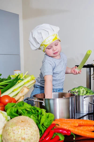 Happy child at kitchen preparing soup — Stock Photo, Image