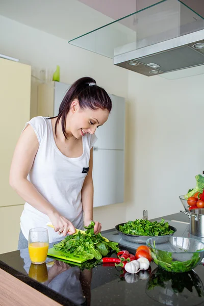Mulher sorridente preparando refeição fresca na cozinha — Fotografia de Stock