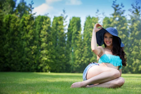 Sexy Frau mit Hut auf Gras liegend — Stockfoto