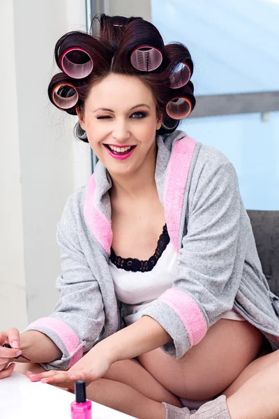 Pregnant woman with hair rollers getting nail treatment — Stock Photo, Image