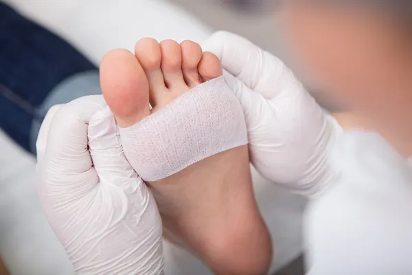 Podiatrist ( chiropodist ) cleaning womans feet ( toenails ) — Stock Photo, Image