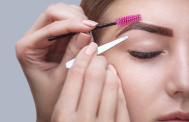 Makyaj malzemesi düzeltir ve daha önce bir güzellik salonunda kınalı kaşlarla boyanmış forseps ile çıkarmak için şekil verir. Profesyonel yüz bakımı.