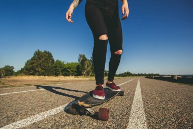 Bir dövme mavi saçlı güzel, seksi sarışın yenilikçi bir longboard biniyor.