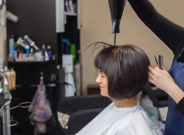 Kapper Droogt Haar Haar Een Brunette Meisje Een Schoonheidssalon — Stockfoto