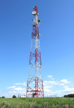 Mavi gökyüzüne karşı antenli iletişim kulesi