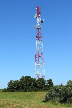 Mavi gökyüzüne karşı antenli iletişim kulesi