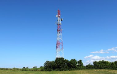 Mavi gökyüzüne karşı antenli iletişim kulesi