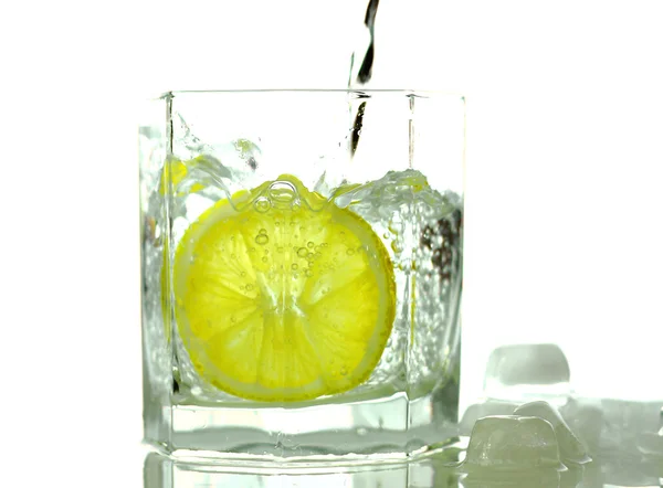 Despejando água doce no copo com limão — Fotografia de Stock