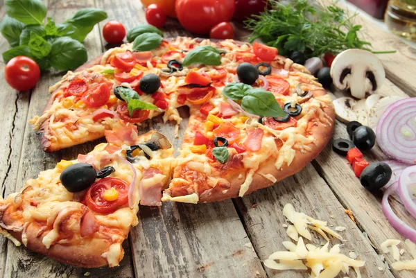 Domácí pizza se šunkou sýrem olivami a rajčaty — Stock fotografie