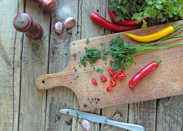 Свежие специи и овощи на кухонной доске — стоковое фото