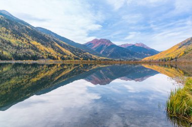 Reflection of autumn aspen trees along Crystal Lake along Red Mountain pass in the San Juan Mountains of Colorado