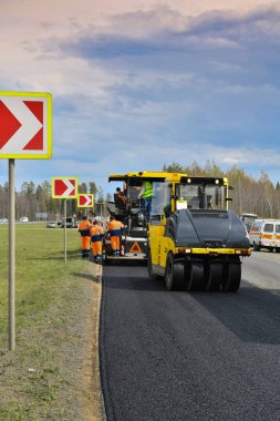 Bir yol silindiri yeni asfaltı sıkıştırır. Yol çalışmaları