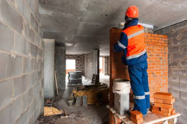 bricklayer builder lays out the brickwork