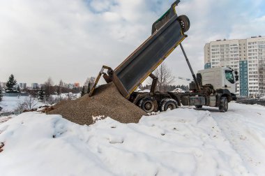 Çöp kamyonu kargoyu inşaat alanına boşaltıyor.