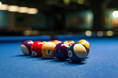 çok renkli bilardo topları bulanık arkaplanı olan bir masanın üzerinde uzanır.